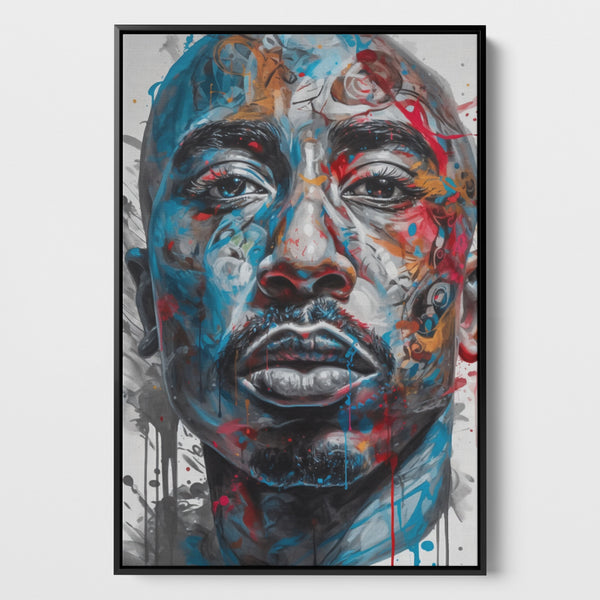 Das Bild zeigt ein lebendiges Porträt von Tupac Shakur mit expressiven, farbenfrohen Akzenten auf einer Leinwand. Der Stil des Kunstwerks ist modern und wirkt fast wie eine Fusion aus Realismus und abstrakter Kunst. Die Farben Blau und Rot dominieren, wobei dynamische Farbspritzer und Ströme über das Gesicht laufen, was dem Bild Energie und Bewegung verleiht. Das Bild ist eingerahmt in einem schwarzen Schattenfugenrahmen.